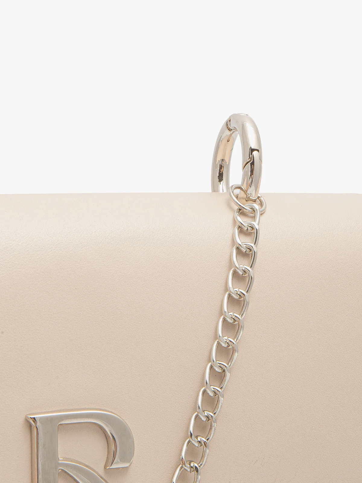 Beżowa torebka typu kopertówka na srebrnym łańcuszku