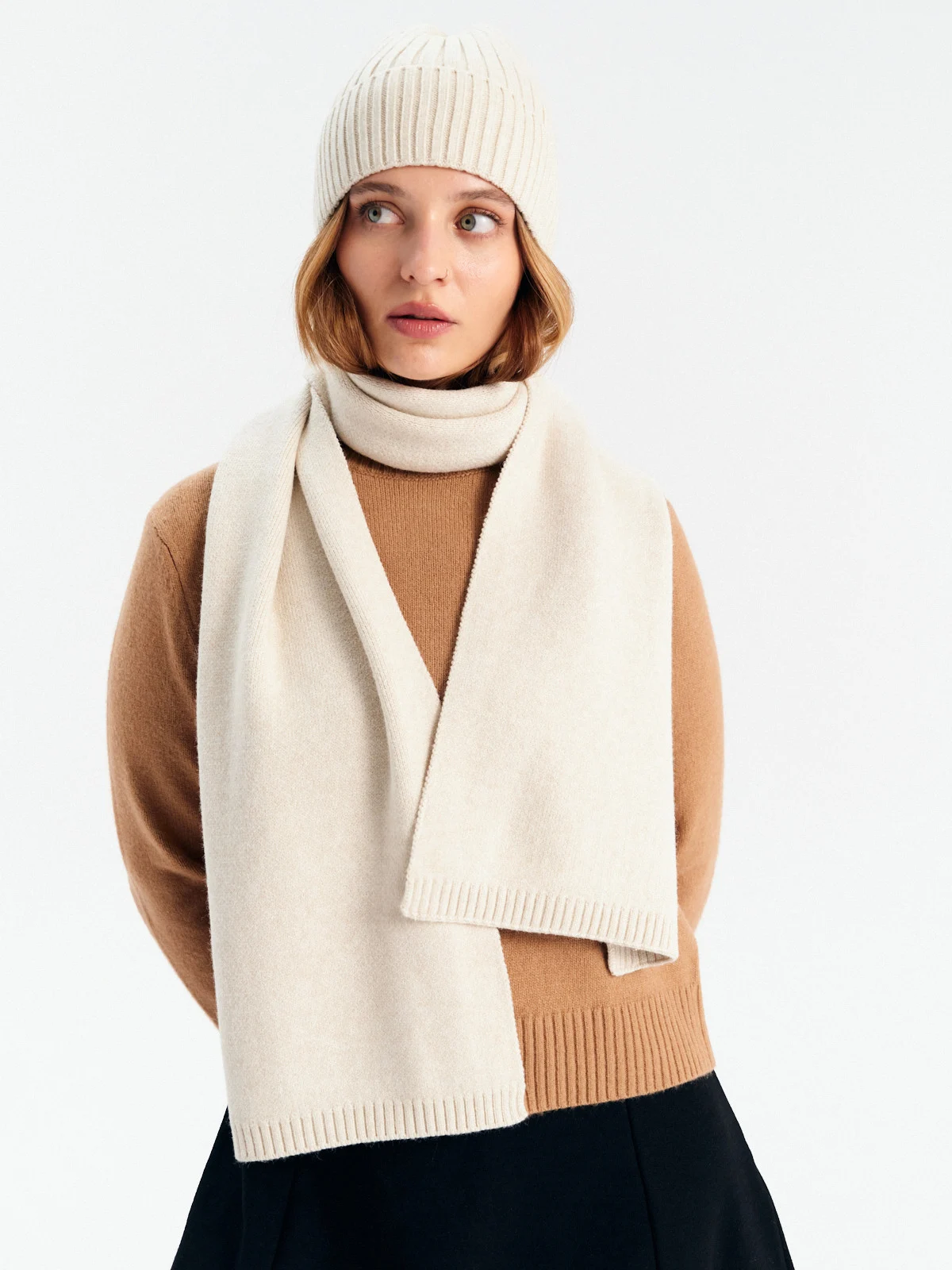 Czapka i szalik wykonane z elastycznej tkaniny z domieszką wełny w kolorze kremowym