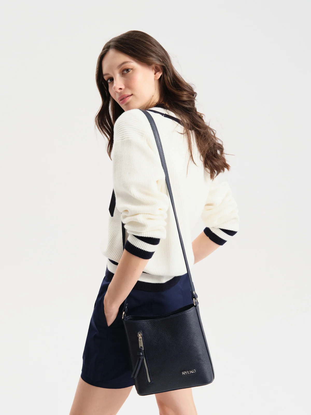 Mała, granatowa torebka listonoszka z dekoracyjnymi zamkami