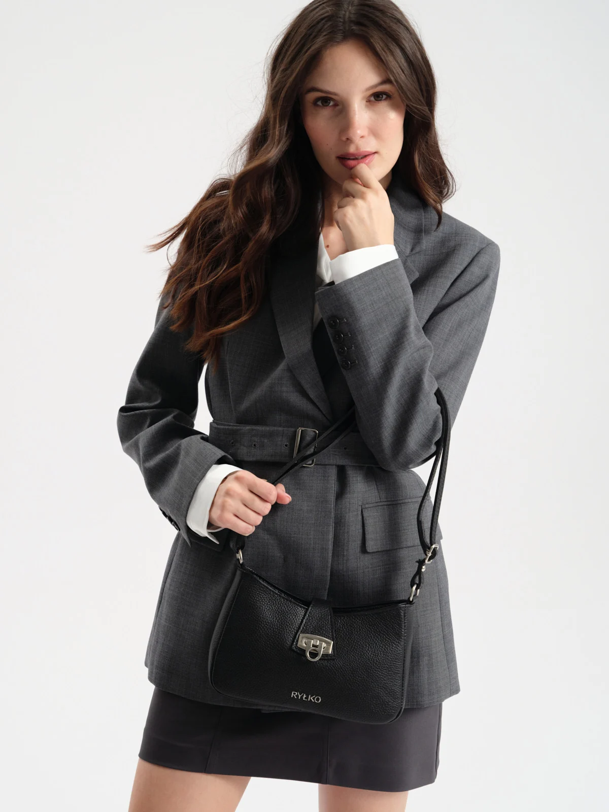 Czarna torebka damska zapinana zdobną klamrą