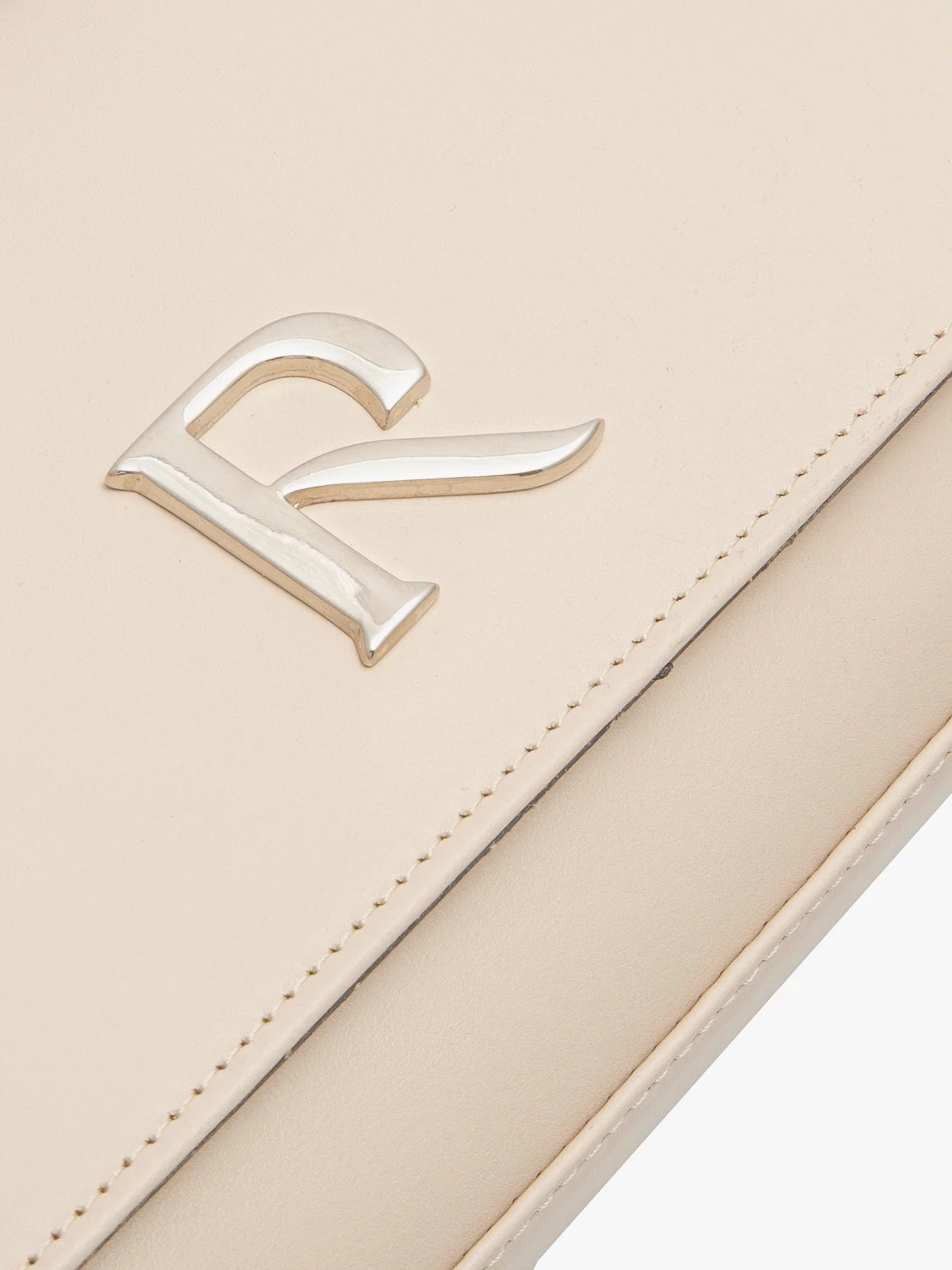 Beżowa torebka typu kopertówka na srebrnym łańcuszku