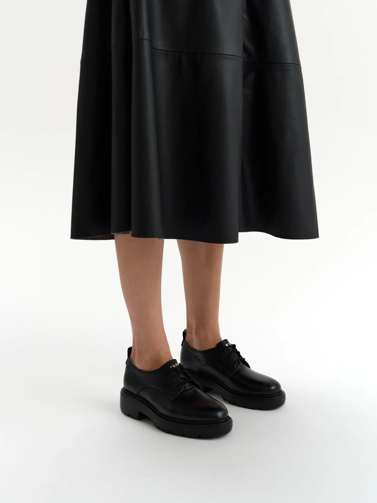 Czarne półbuty ze złotym logotypem na języku