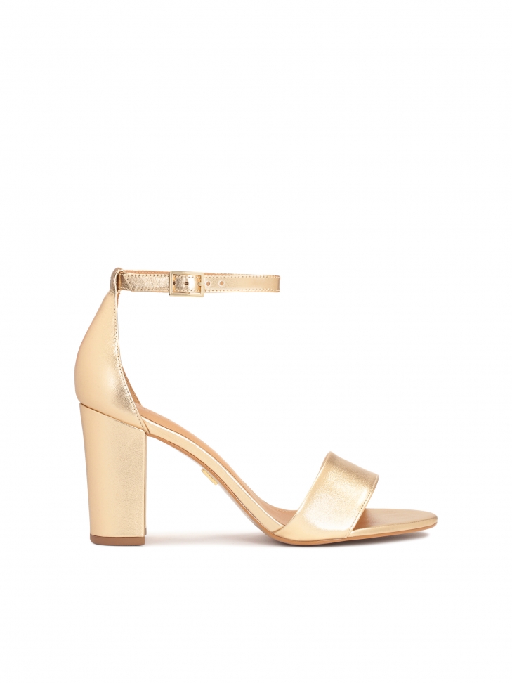 Złote sandały na słupku z paskiem wokół kostki