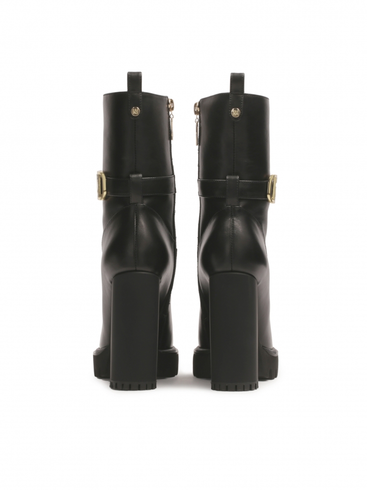 Czarne botki z monogramem KAZAR osadzone na słupku