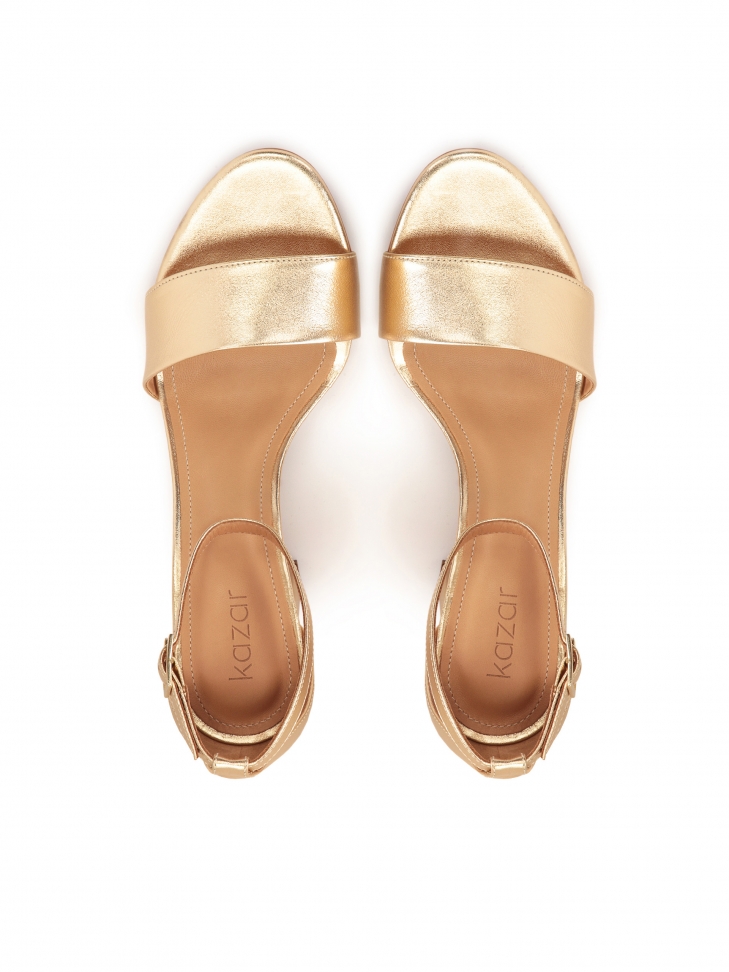 Złote sandały na słupku z paskiem wokół kostki