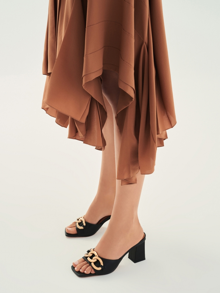 Skórzane klapki na słupku ozdobione grubym łańcuchem