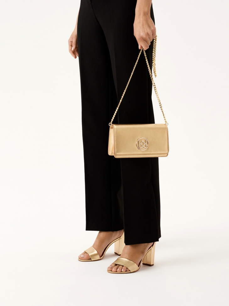 Złote sandały na słupku z paskiem wokół kostki