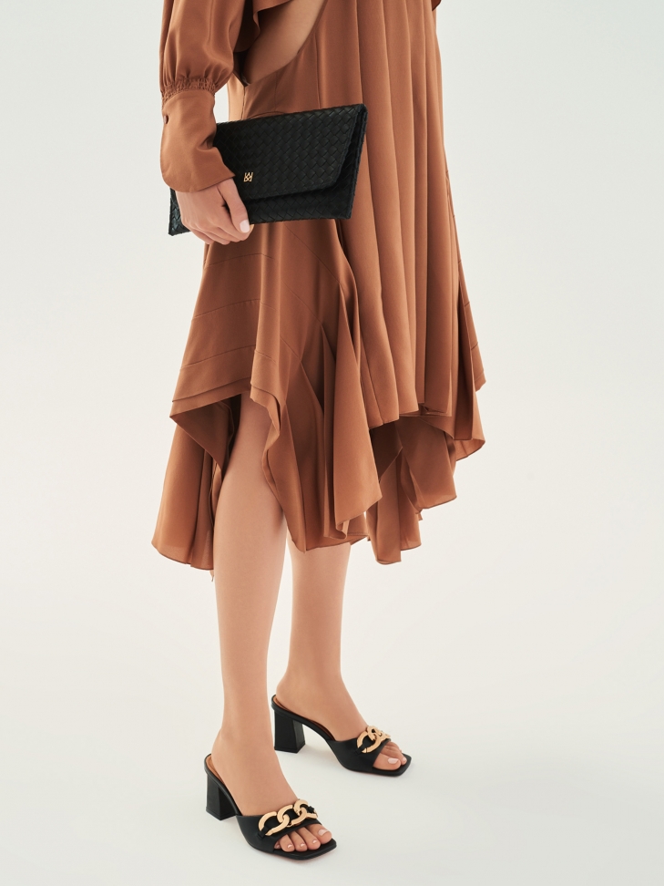 Skórzane klapki na słupku ozdobione grubym łańcuchem