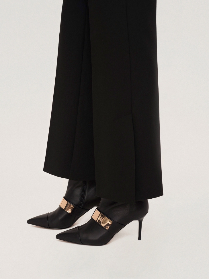 Klasyczne skórzane botki z noskami w szpic i dużą metalową ozdobą