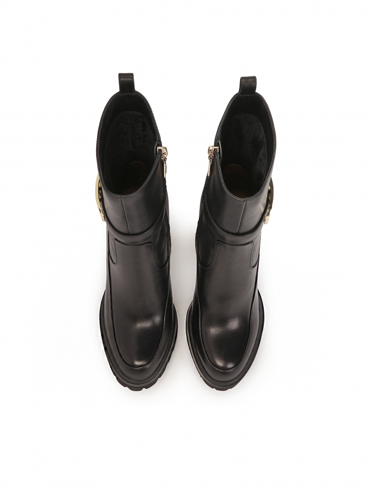 Czarne botki z monogramem KAZAR osadzone na słupku