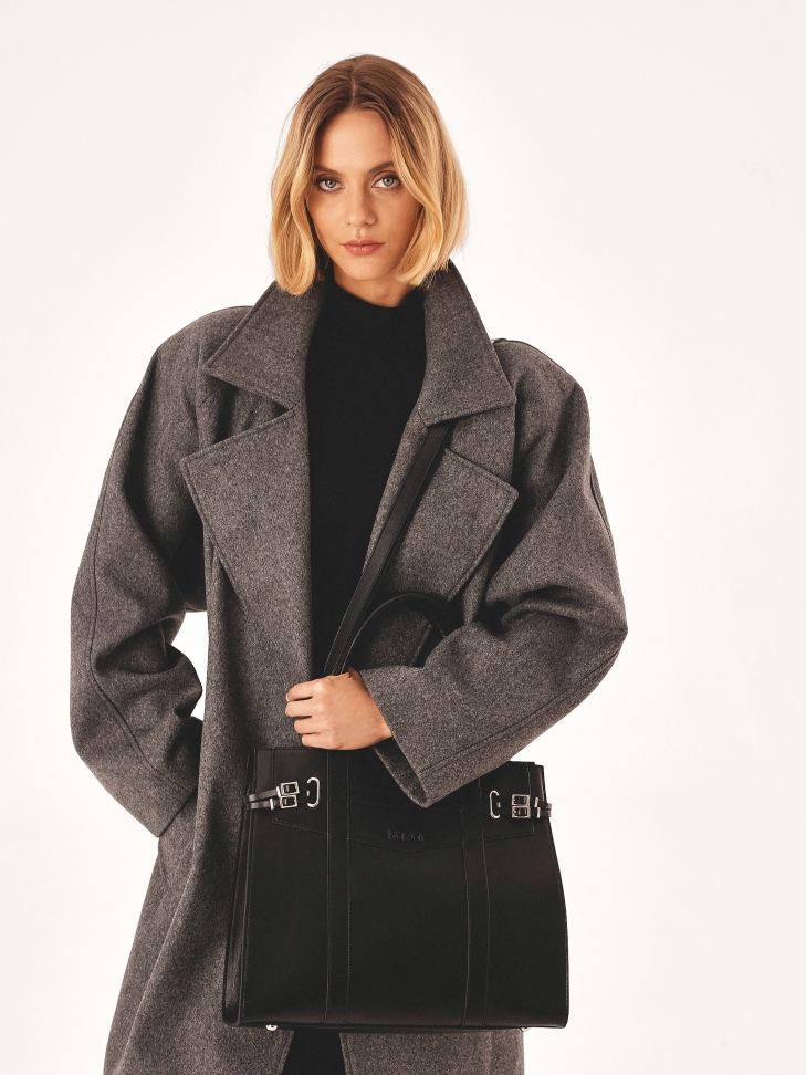 Czarna torebka zdobiona paskami ze sprzączkami