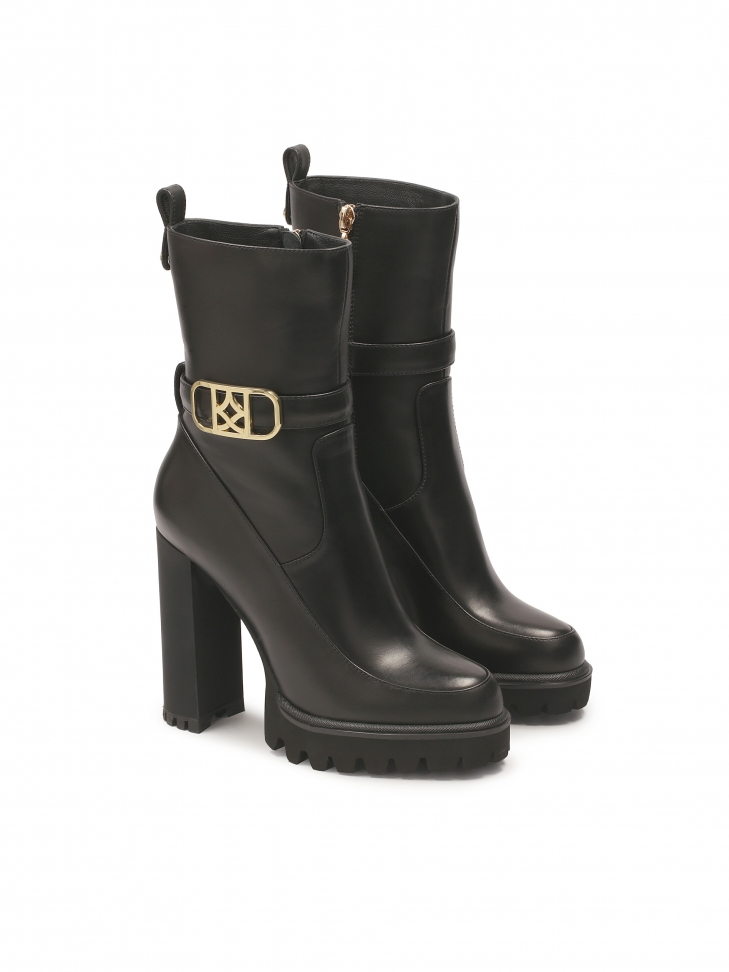 Czarne botki z monogramem KAZAR osadzone na słupku