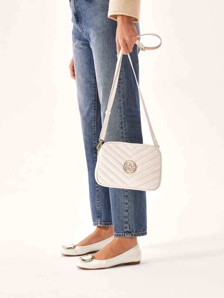 Białe skórzane baleriny zdobione metalową broszką