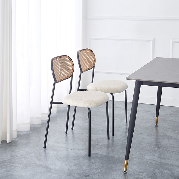 Zestaw 2 krzeseł z metalu i wikliny z białym siedziskiem.