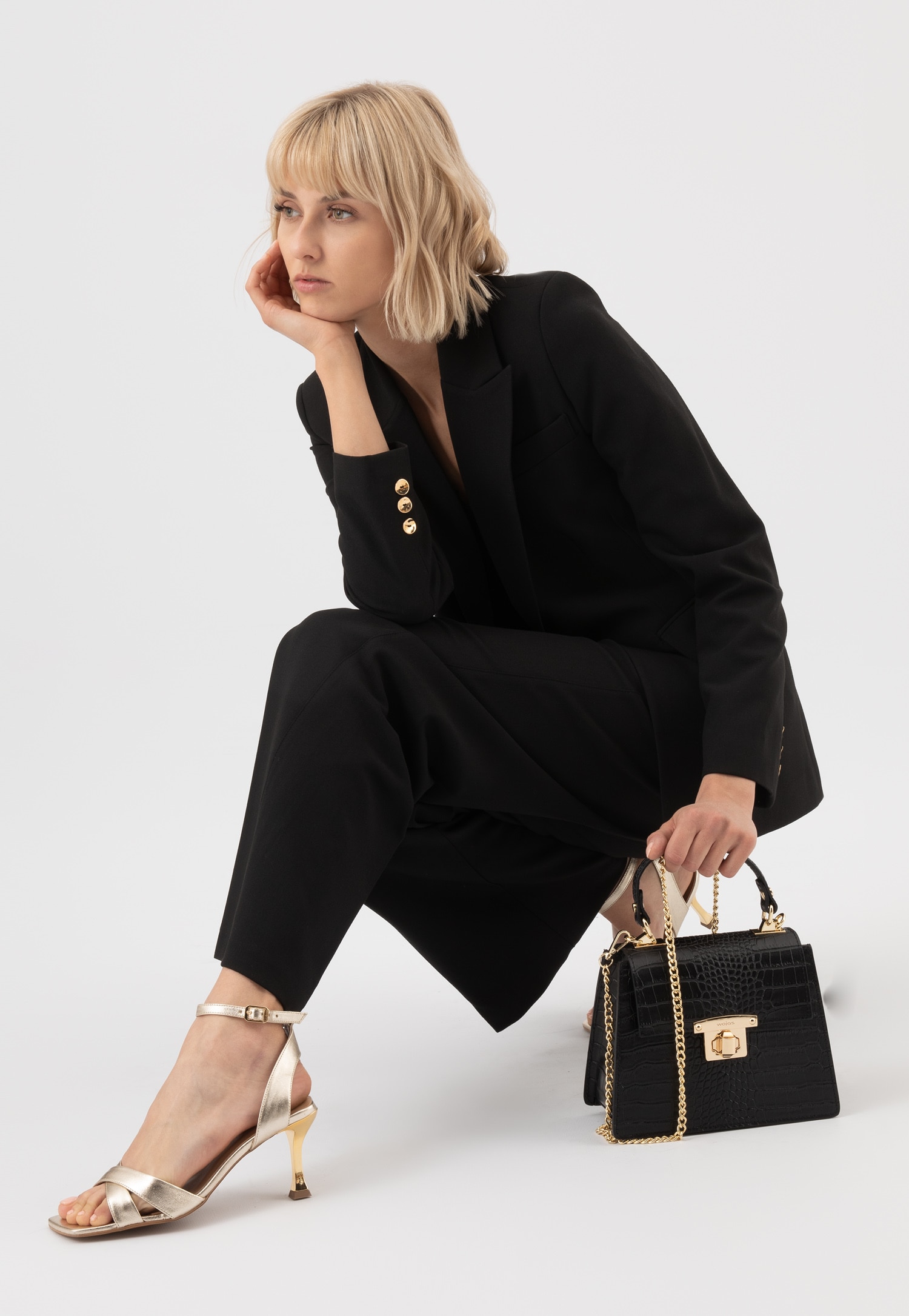 Czarny elegancki kuferek ze złotymi akcentami