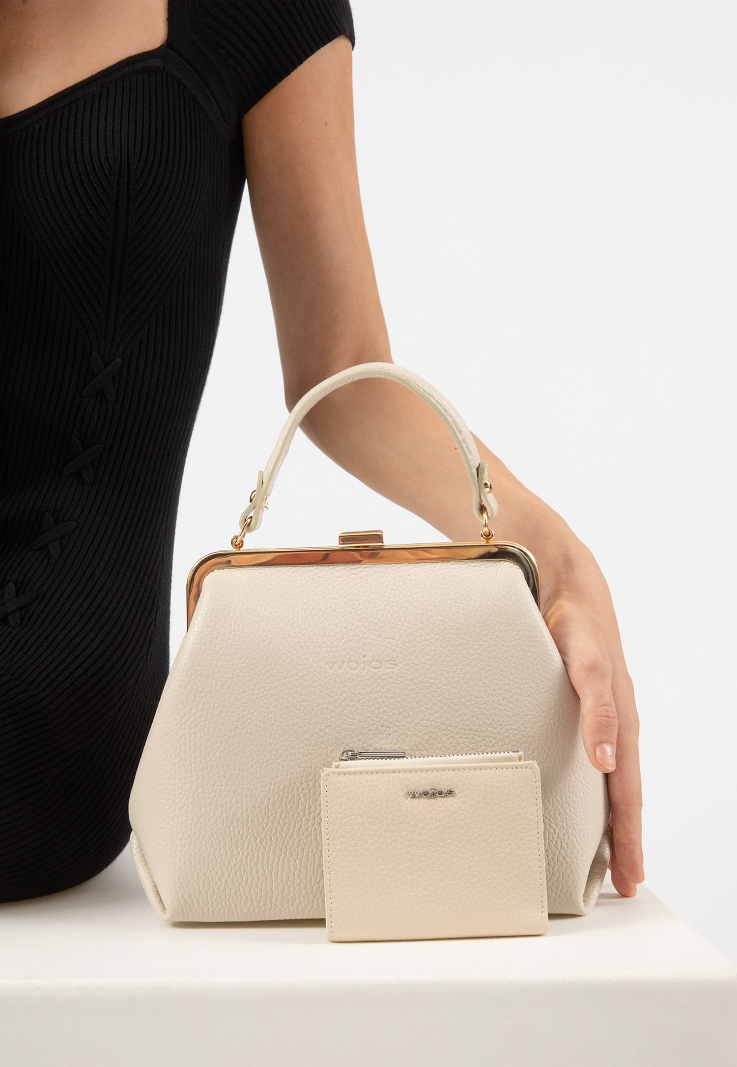 Beżowa torebka damska typu frame bag ze złotymi metalowymi elementami