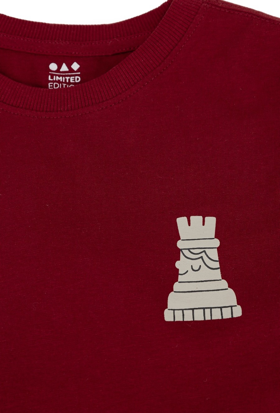 Czerwona koszulka chłopięca z nadrukiem figury szachowej.