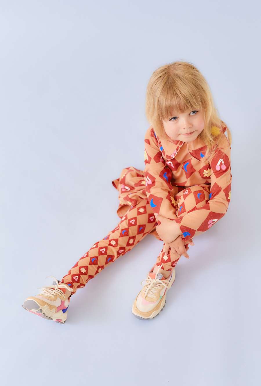 Pomarańczowe legginsy dziewczęce z motywem cyrkowym.