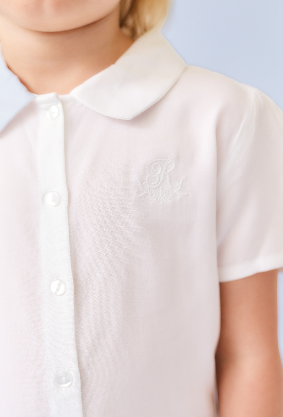 Biała koszula dziewczęca z ótkim rękawem i haftem.