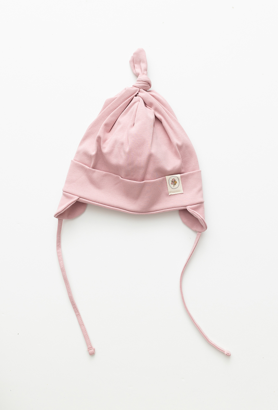 Różowa czapka niemowlęca z wiązaniem i naszywką.