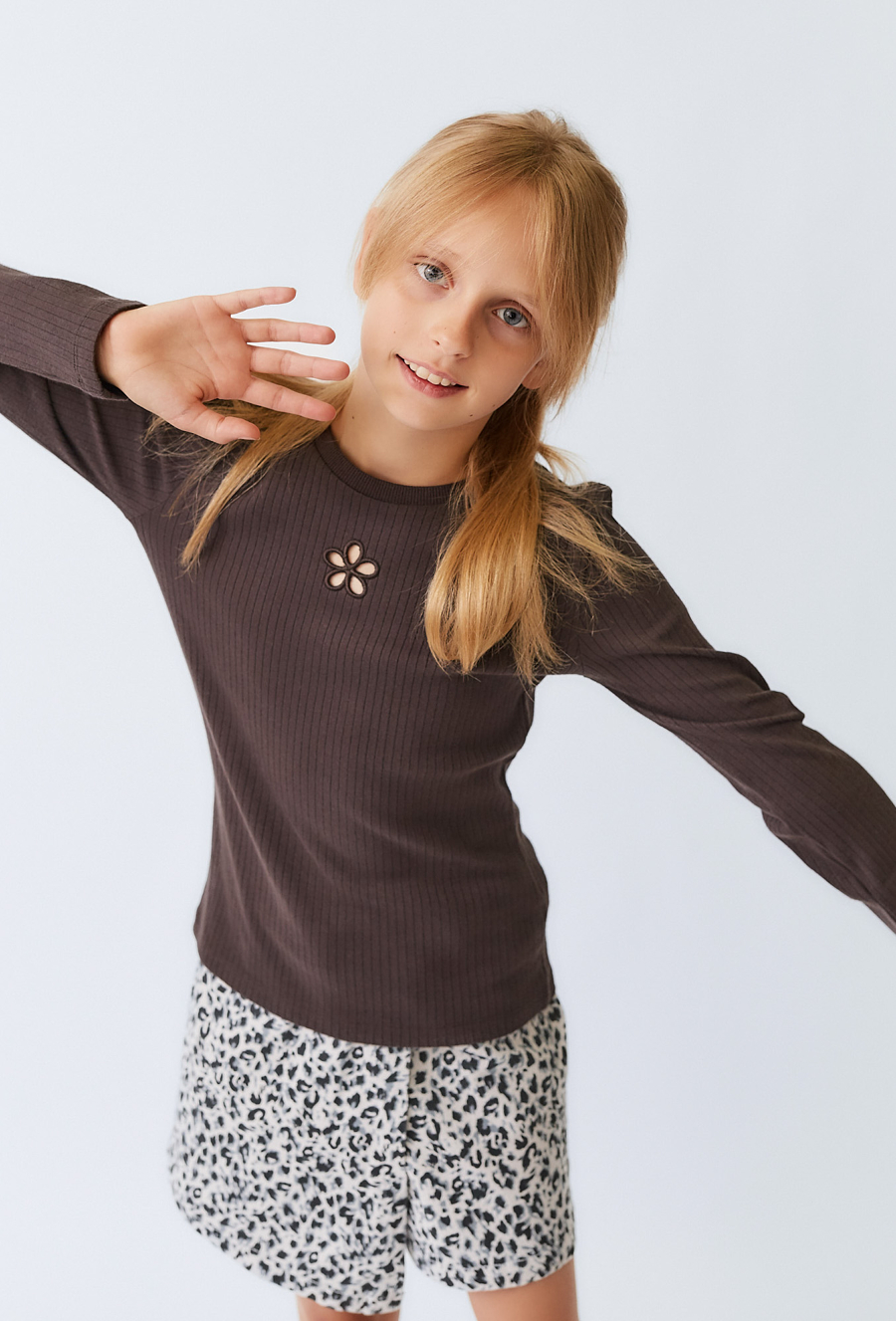 Brązowa bluzka dziewczęca z ozdobnym wycięciem na długi rękaw.