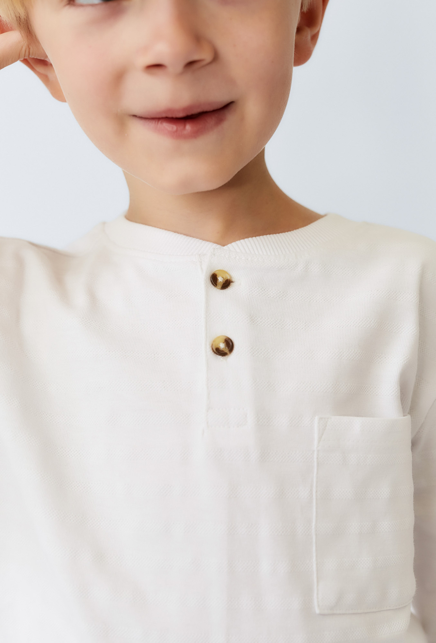 Biała bluzka chłopięca z długim rękawem – strukturalny materiał.