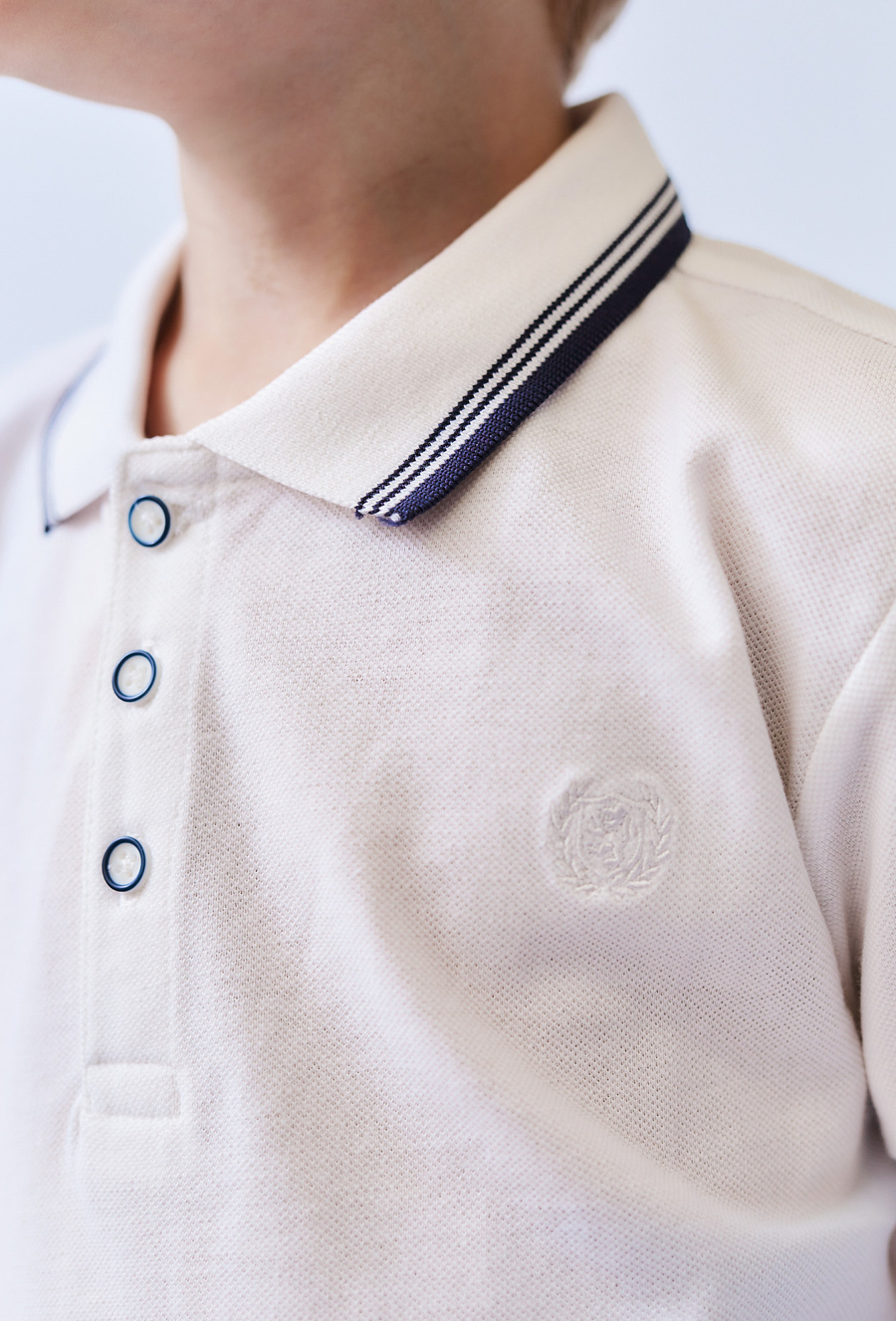 Białe polo chłopięce z kołnierzykiem.