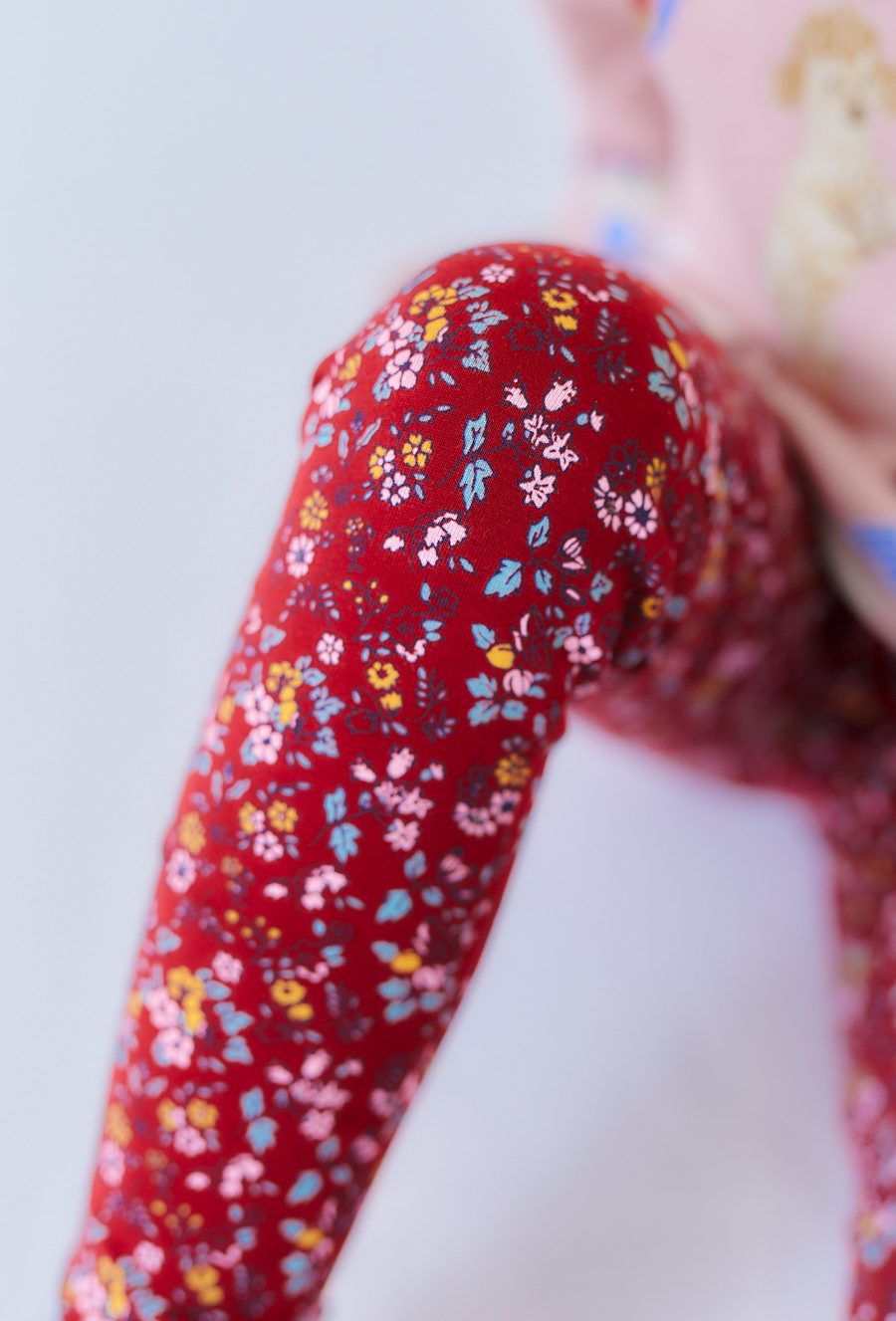 Czerwone legginsy dziewczęce z kwiatowym nadrukiem.