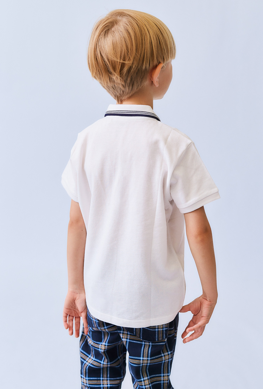 Białe polo chłopięce z kołnierzykiem.