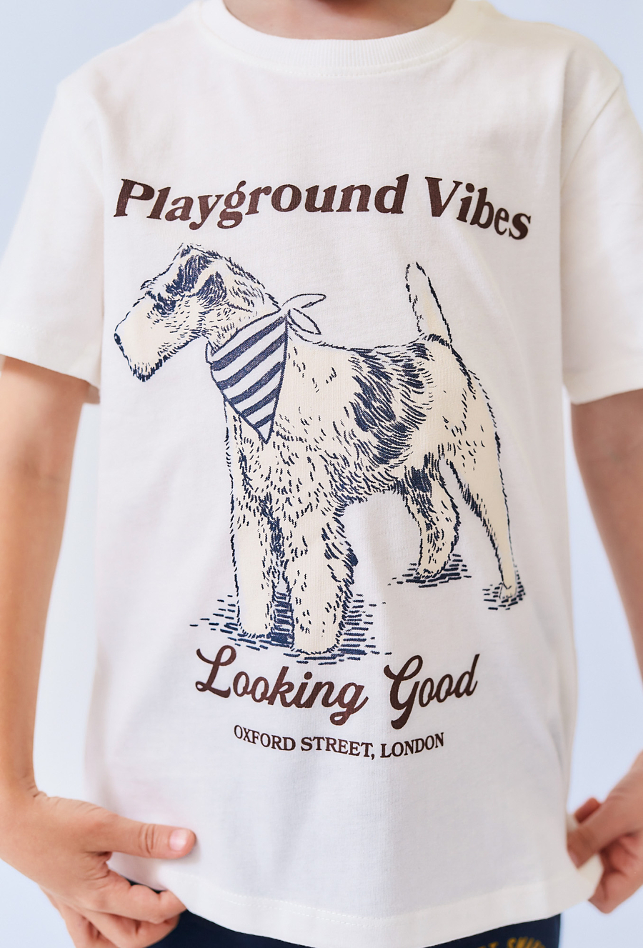 Biała koszulka chłopięca z nadrukiem pieska i napisem.