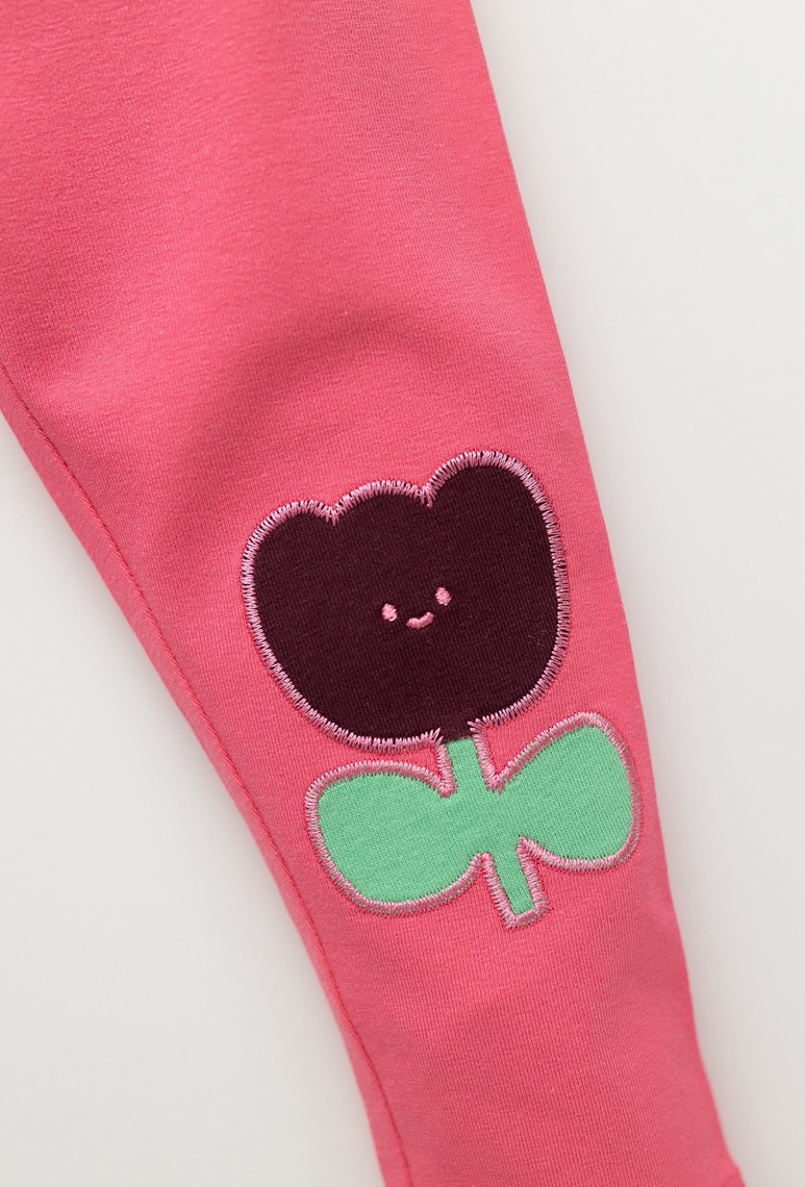 Różowe legginsy niemowlęce z naszywkami kwiatków na kolankach