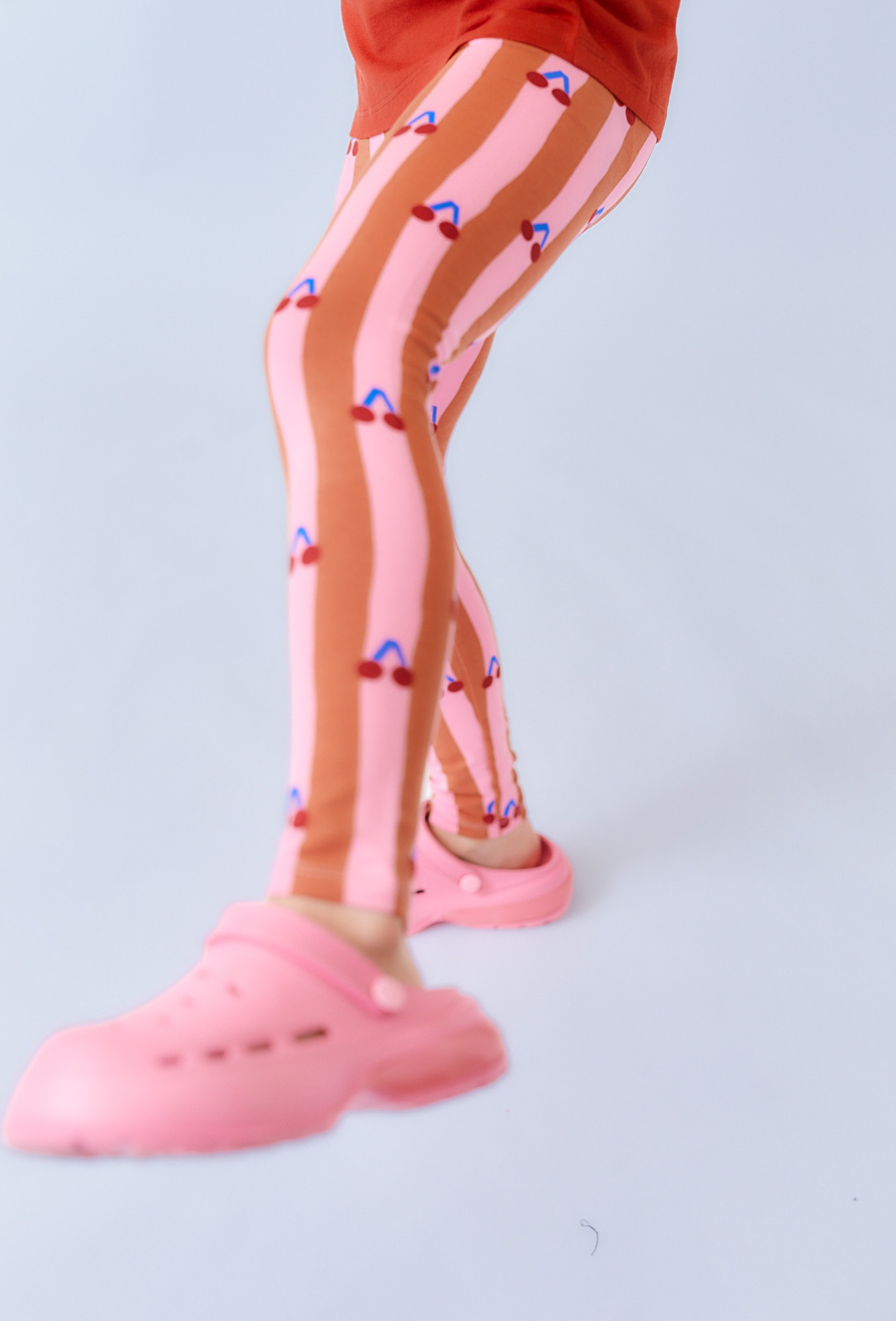 Różowo-brązowe legginsy dziewczęce z nadrukiem wisienek.