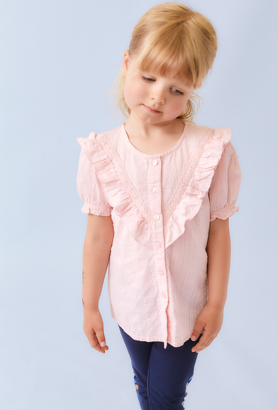 Różowa koszula dziewczęca z ótkim rękawem i falbanką.