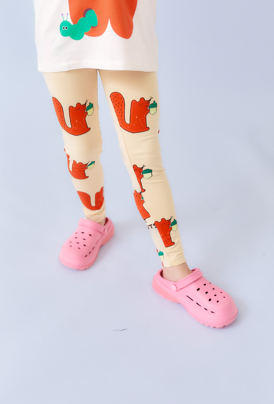 Beżowe legginsy dziewczęce z motywem wiewiórek i żołędzi.