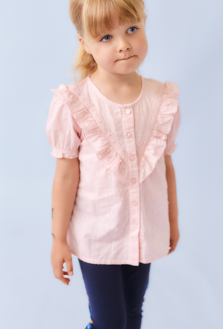 Różowa koszula dziewczęca z ótkim rękawem i falbanką.