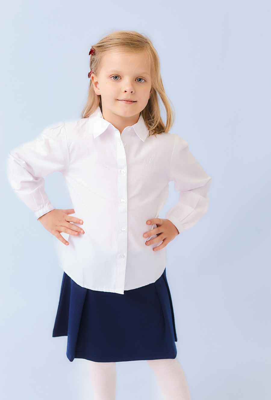 Biała koszula dziewczęca z długim rękawem i haftem.