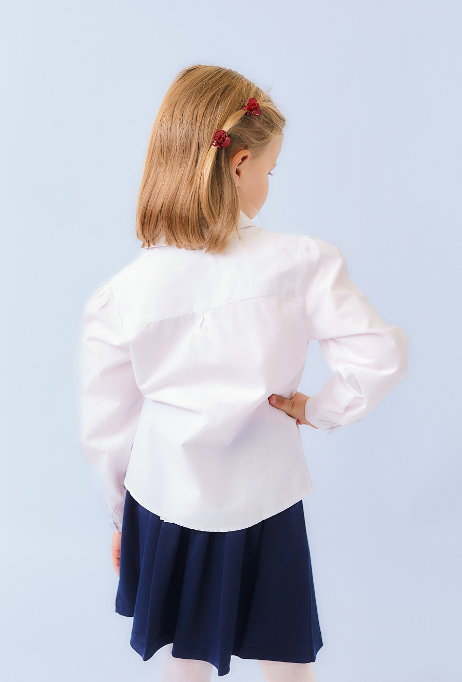 Biała koszula dziewczęca z długim rękawem i haftem.