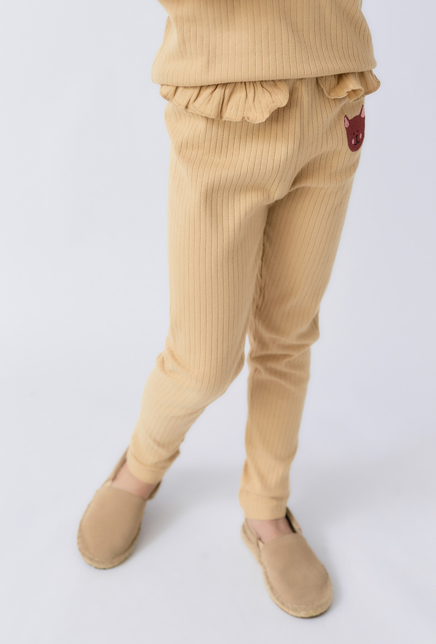 Dziewczęce prążkowane legginsy z falbanką i aplikacją kotka