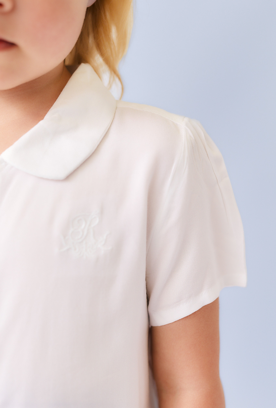 Biała koszula dziewczęca z ótkim rękawem i haftem.