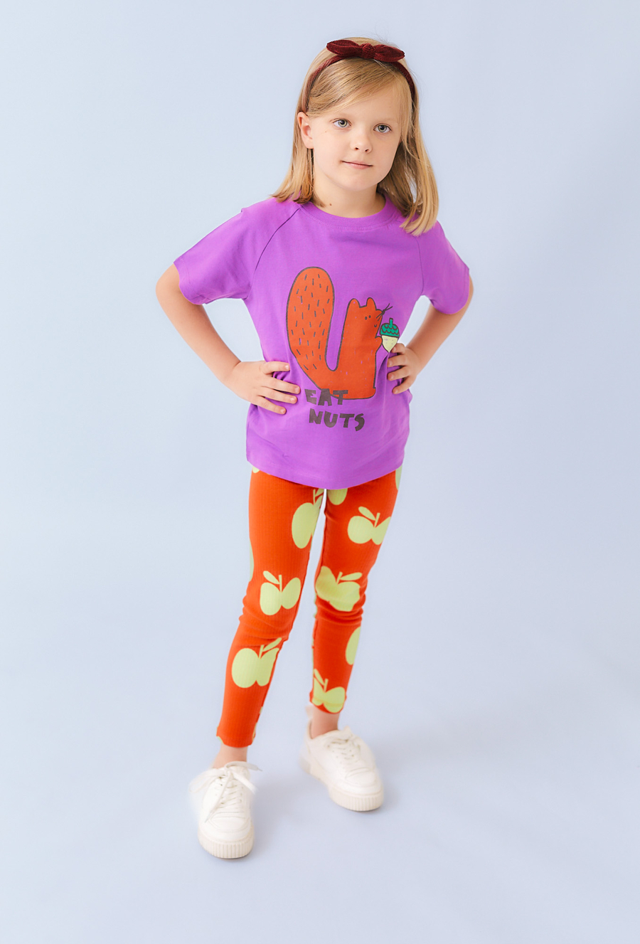 Pomarańczowe legginsy dla dziewczynki z motywem jabłek.
