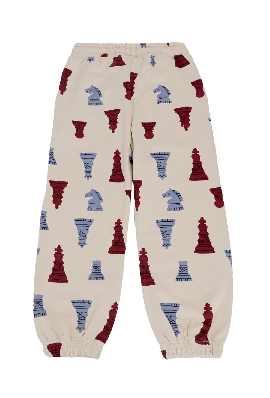 Beżowe spodnie dresowe dziecięce z motywem szachowym.