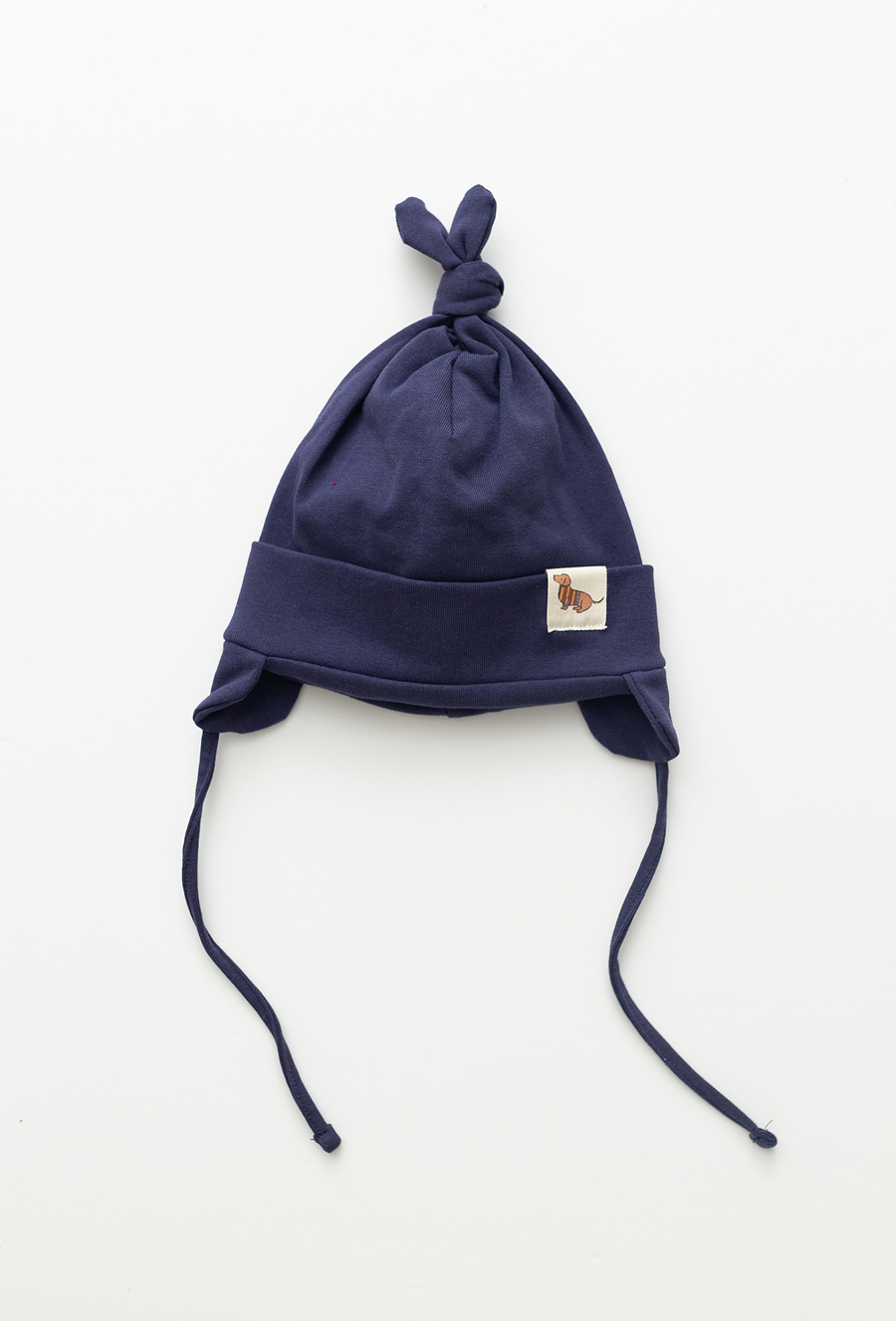 Granatowa czapka niemowlęca z wiązaniem i naszywką.