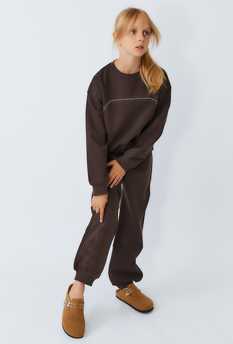 Brązowe spodnie dresowe dziewczęce baggy z wypukłym nadrukiem.