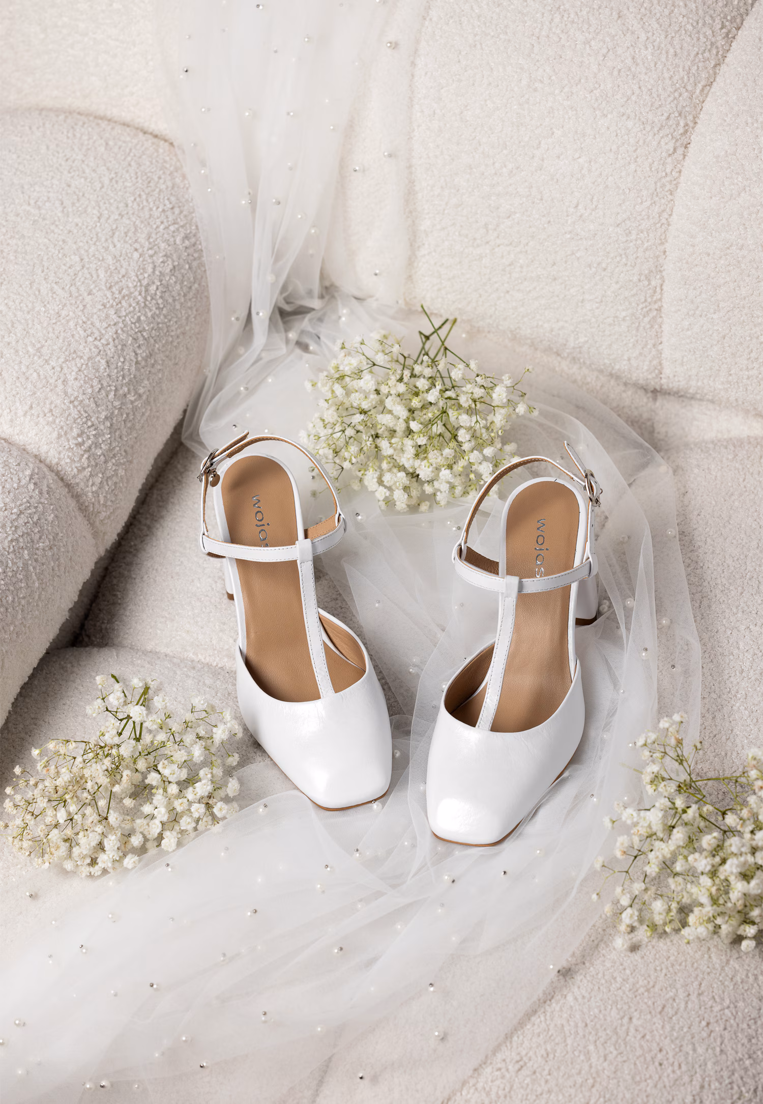 Białe czółenka na słupku z odkrytą piętą